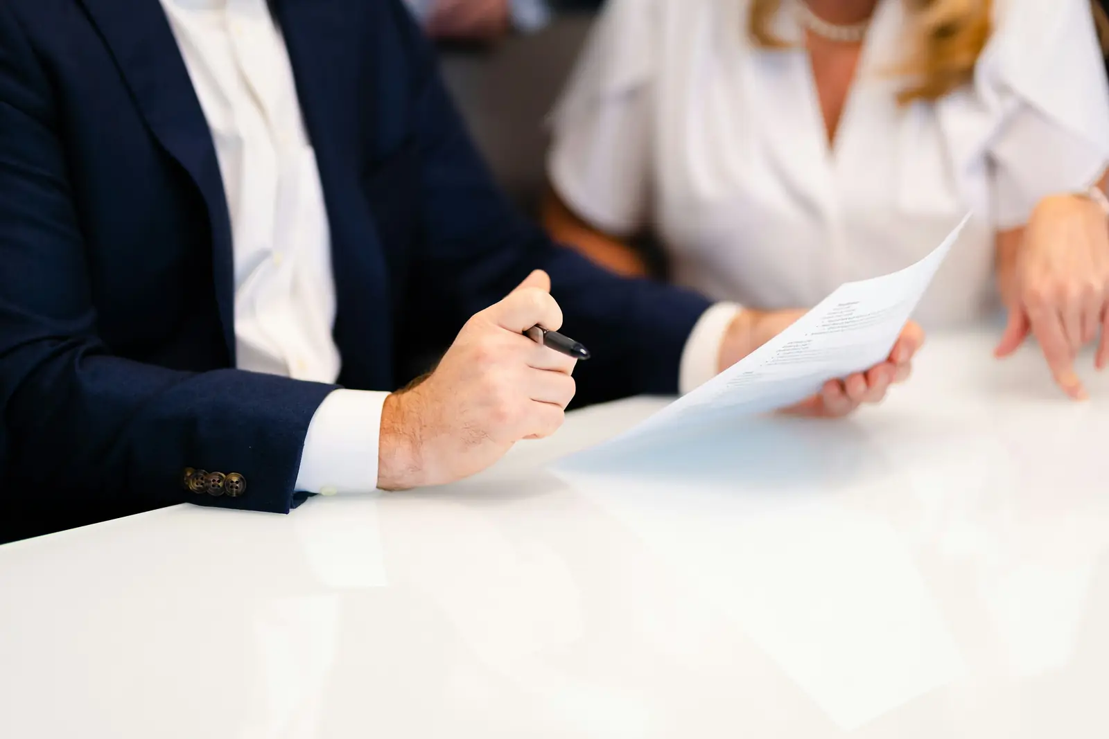 محامٍ وموكلة يراجعان مستندًا على مكتب